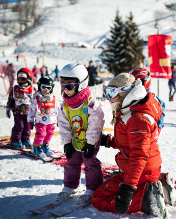 Monitrice de ski qui accompagne l'apprentissage des enfants
