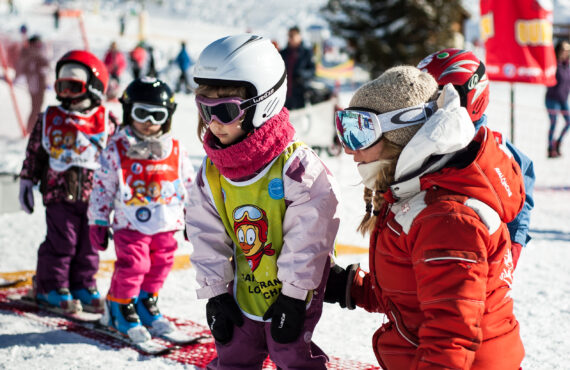 Monitrice de ski qui accompagne l'apprentissage des enfants