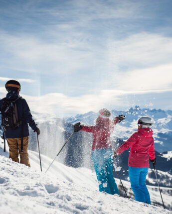 Skieurs sur piste de ski au soleil avec neige fraîche