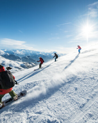 Snowboard et ski sur piste neige et soleil