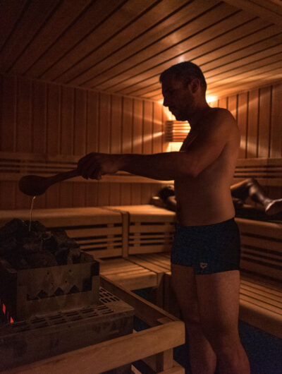 Personne qui ajoute de l'eau dans un sauna