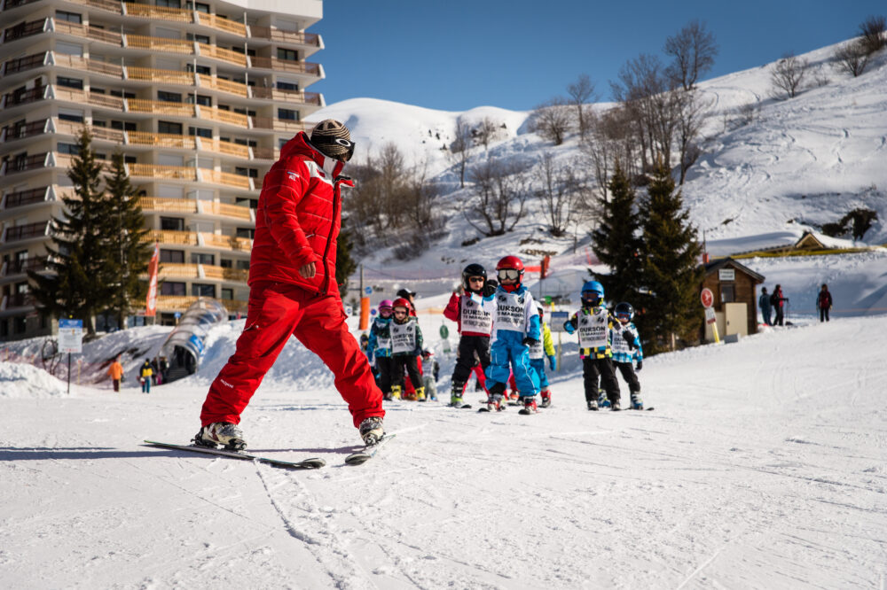 Moniteur de ski avec groupe d'enfant